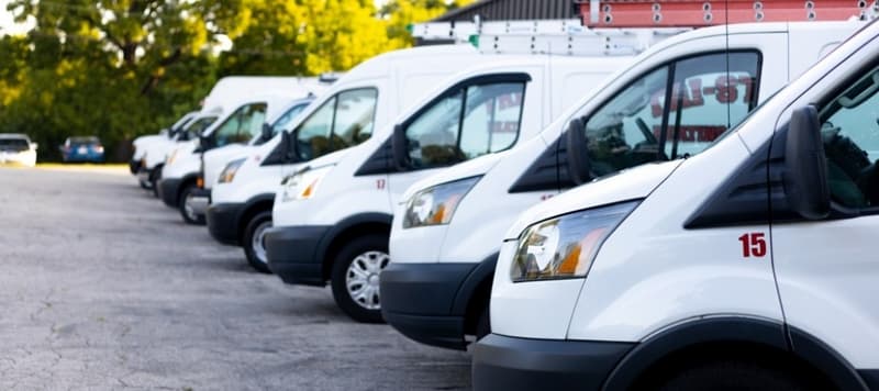 Row of white service vans parked in a lot